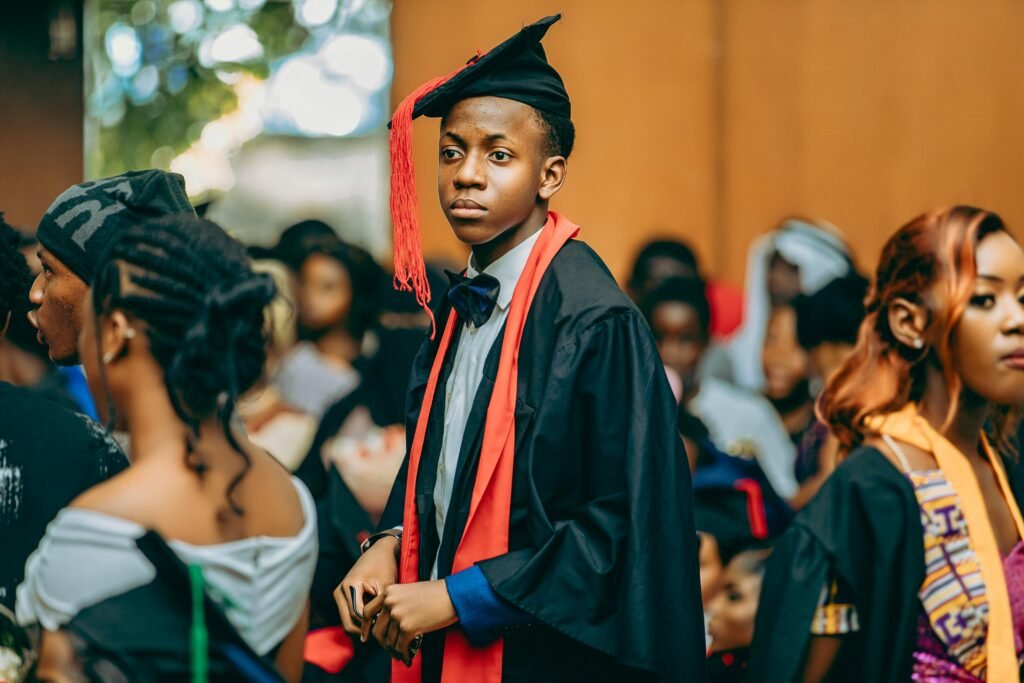 Group of students celebrating graduation, wearing gowns and caps at a ceremony.